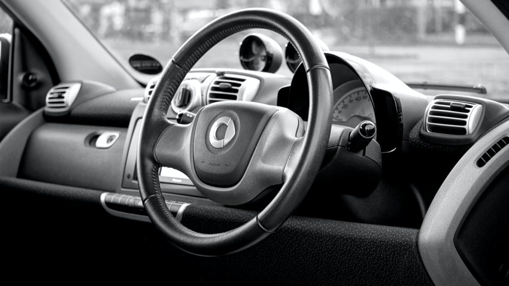 Volant et tableau de bord de l'intérieur d'une voiture, photographie en noir et blanc